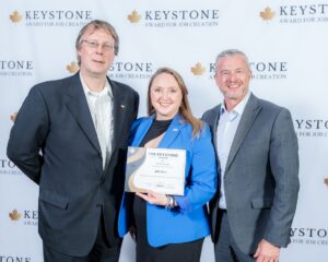 The people stand for a photo holding an award.