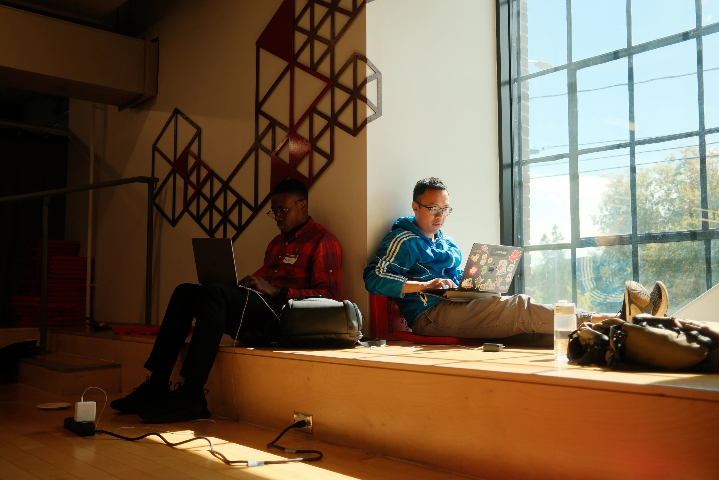 Two professionals work on laptops in a bright, modern space, reflecting Ottawa’s highly skilled and collaborative tech talent.