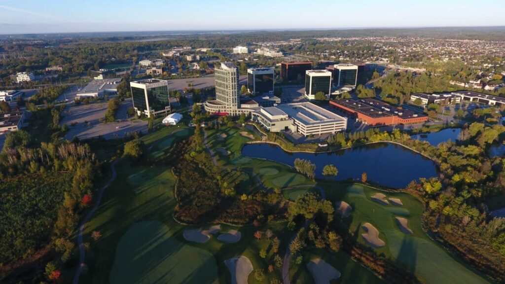 Aerial view of Kanata North’s tech park, featuring modern office buildings surrounded by green space, a golf course, and a pond.