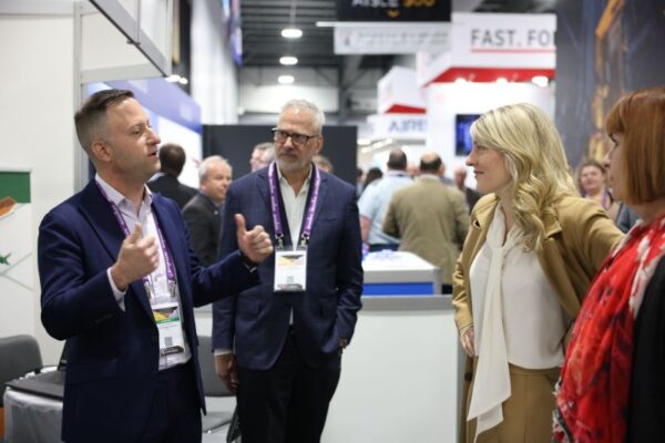 Professionals discussing technology at an industry trade show, highlighting collaboration and innovation in Ottawa.