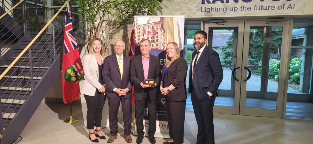 Group of business and government leaders at an AI event, with one person receiving an award, highlighting collaboration and innovation in Ottawa.