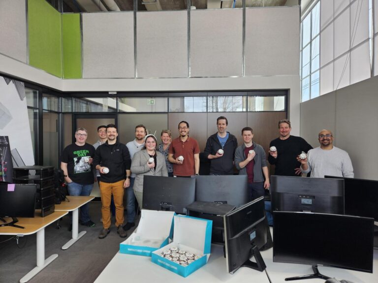 Team of professionals in an office holding branded items, representing collaboration and workplace culture in Ottawa’s tech sector.