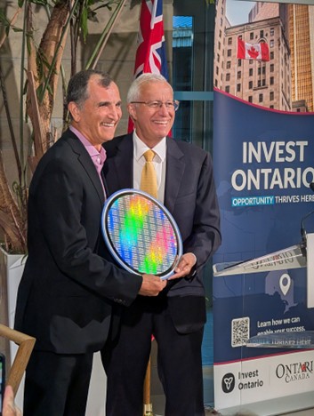 Two business leaders holding a semiconductor wafer award at an Invest Ontario event, highlighting innovation and technology leadership.